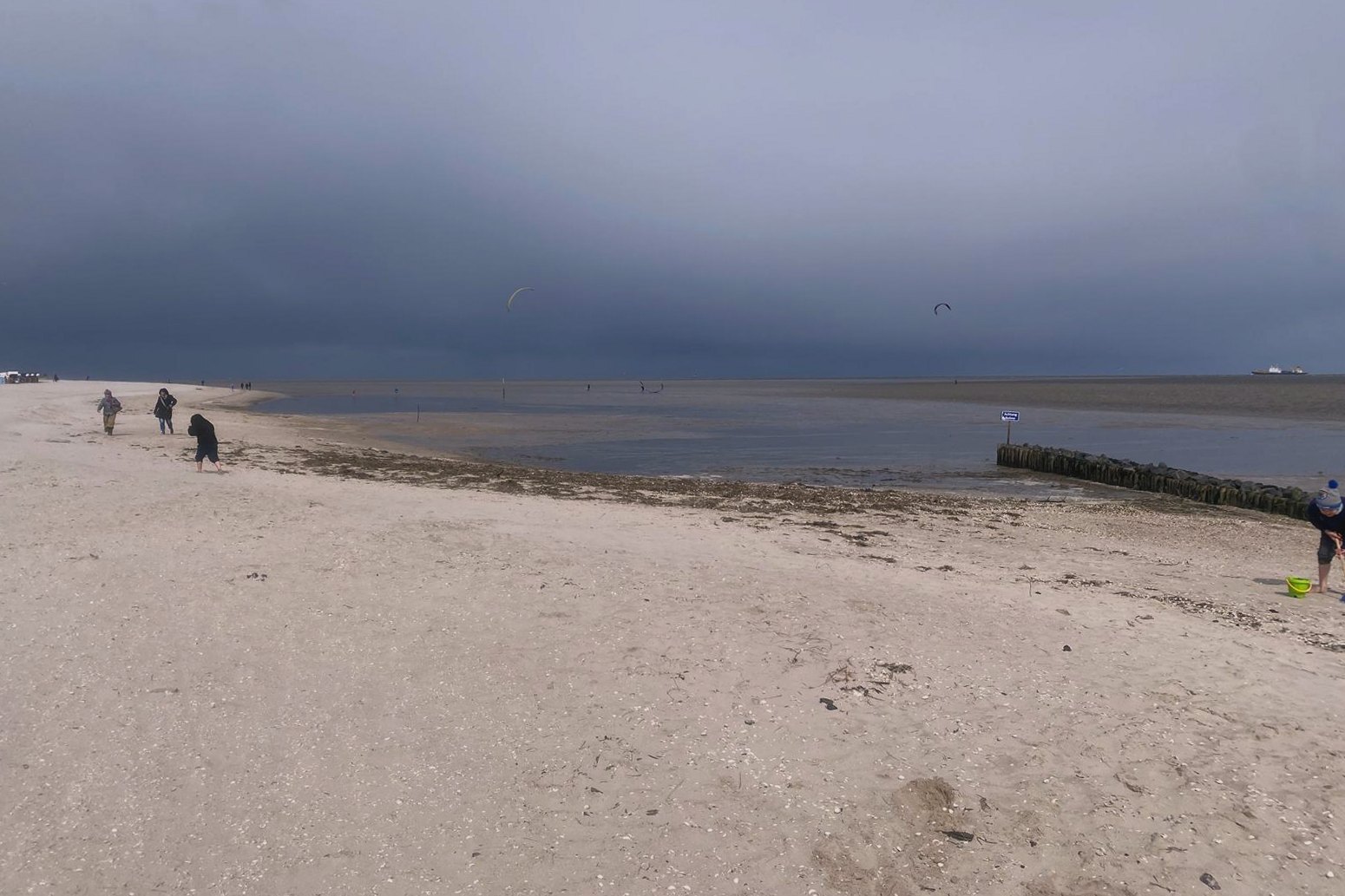Weiter Strand unter grauem Himmel